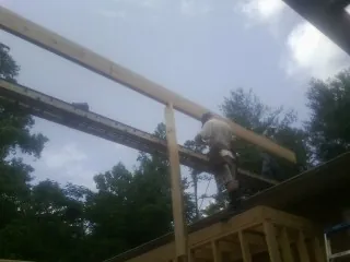 Carpenter setting a ridge beam over a new addition frame — Ice Dam Removal by Roofing Brothers in New Castle